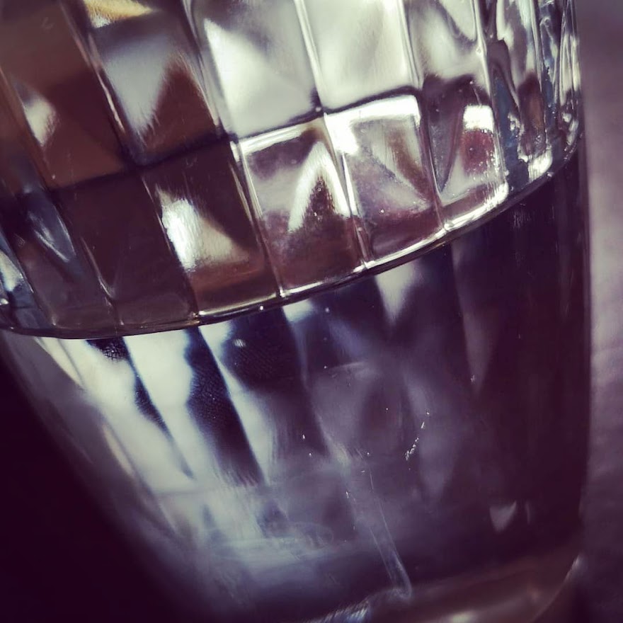 Half a glass full of a clear sparkling liquid. It could be G&T or it could just be lemonade...